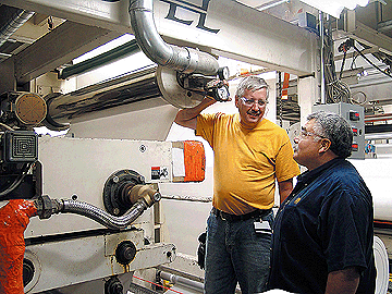 Special projects coordinator Mike Mendolla (right) and operator Rick Gezella are shown with one of the 12 vacuum rolls in use at Green Bay Packaging. This one is positioned immediately after an overhead dryer.