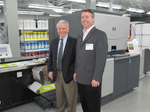 Mike Ferrari of Procter & Gamble and president Jay Dollries of Innovative Label Solutions stand in front of ILS’s newest HP WS6000 digital press.
